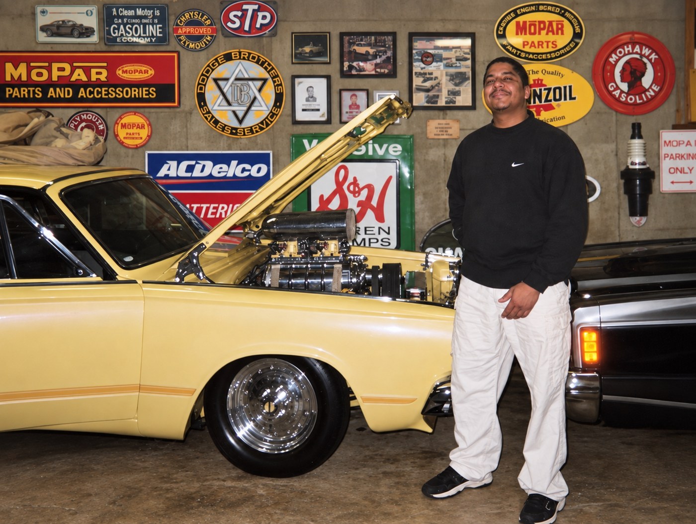 Mark, founder of Compassion Care, standing beside a yellow classic car.
